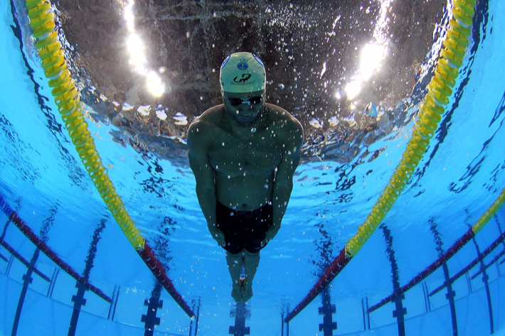 Como a transição da natação subaquática para a natação de superfície deve ser realizada por nadadores competitivos?